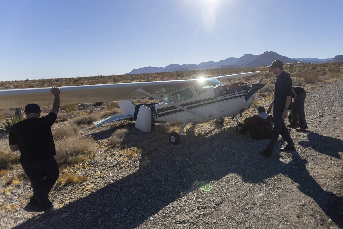 A crew of men, who declined to give their names, work on a plane after it emergency landed on K ...