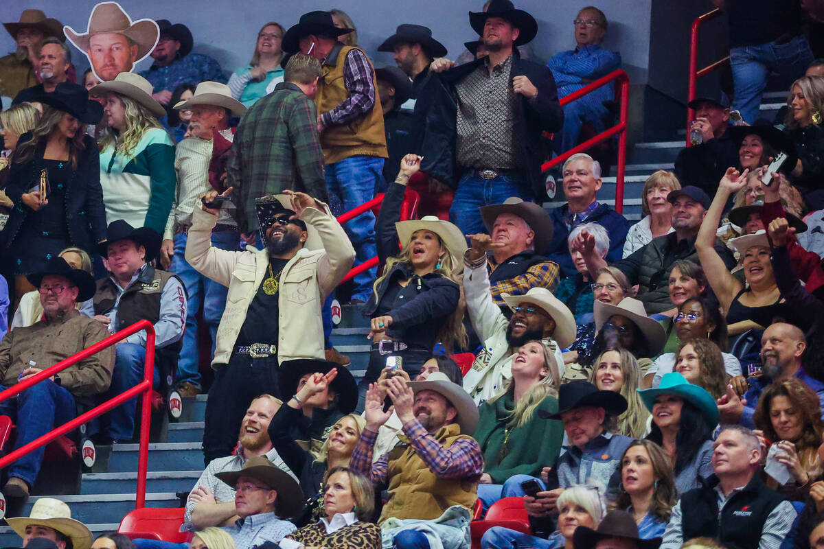 Rodeo fans dance during round three of the National Finals Rodeo at the Thomas & Mack Cente ...