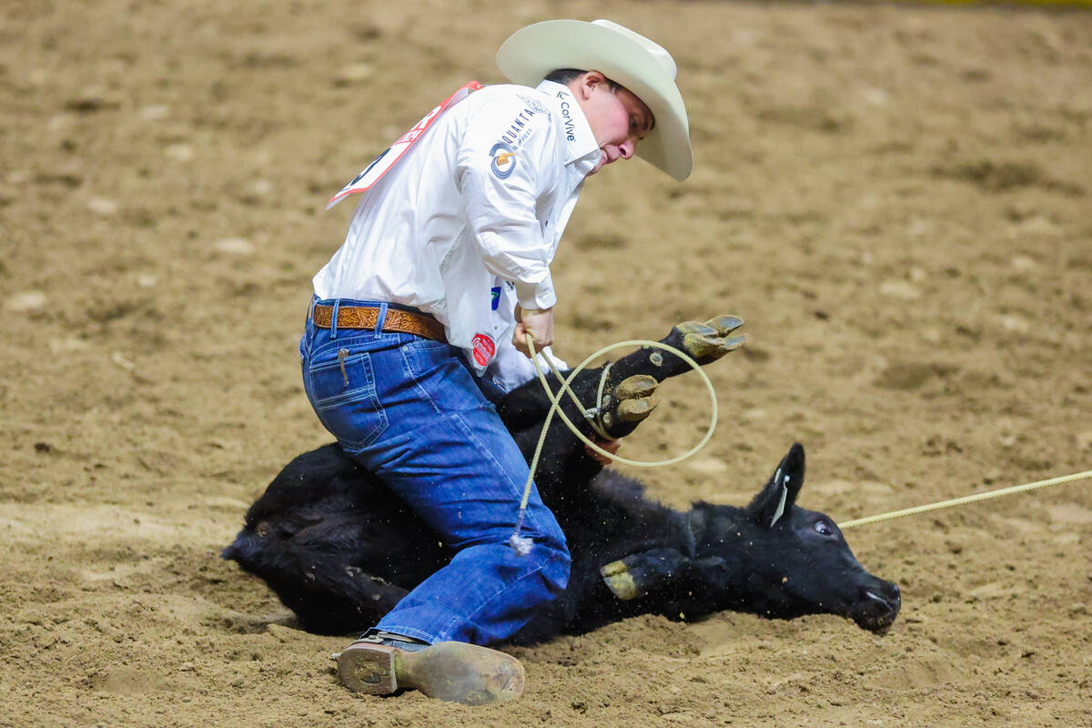 Tie-down roper Riley Webb ties up the calf during round three of the National Finals Rodeo at t ...