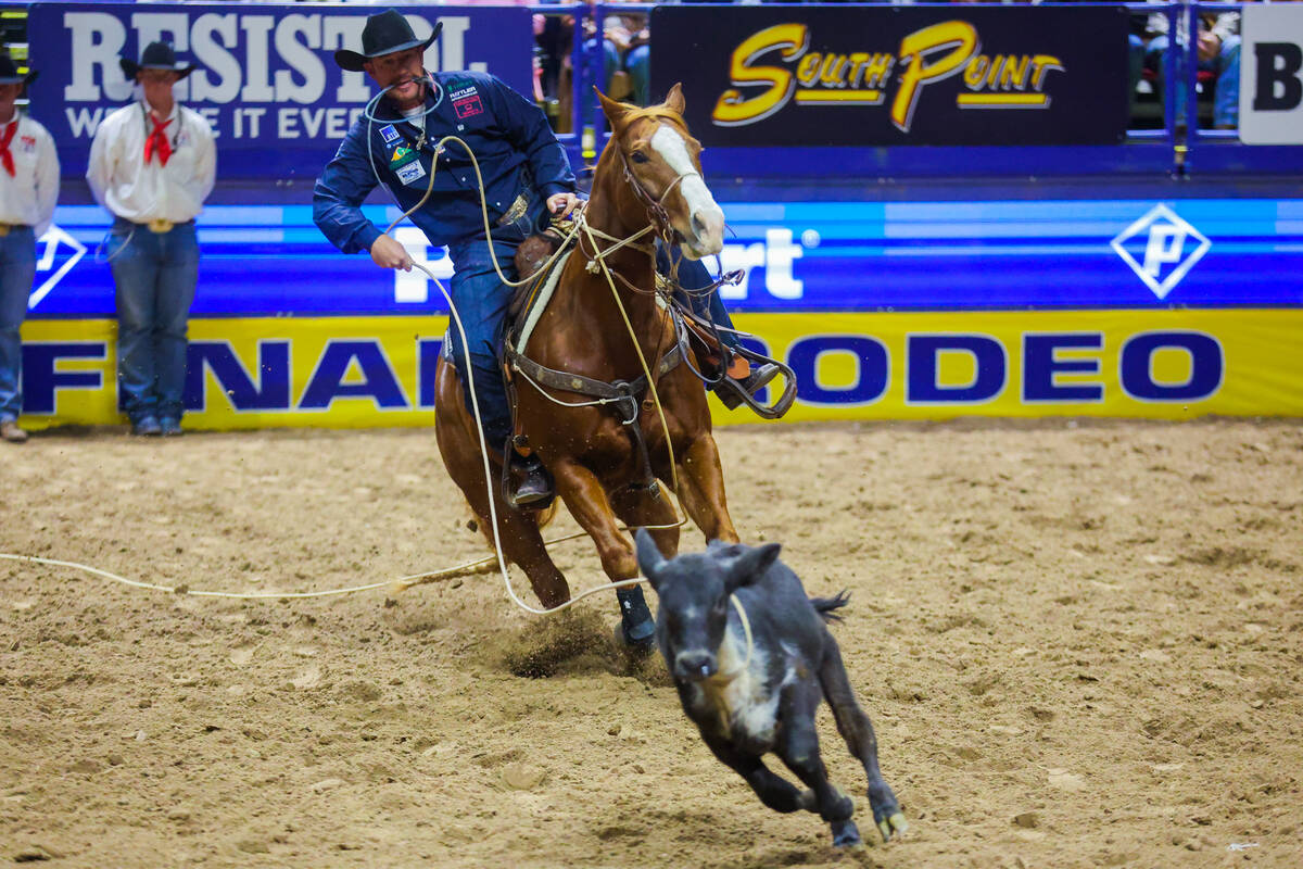 Tie-down roper Hunter Herrin chases the calf during round three of the National Finals Rodeo at ...