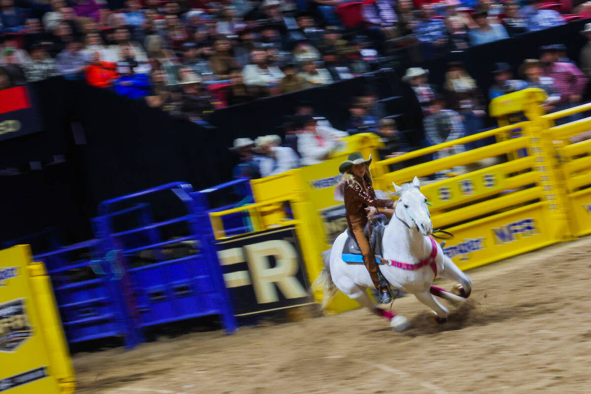 Barrel racer Tiany Schuster races into the arena during round three of the National Finals Rode ...