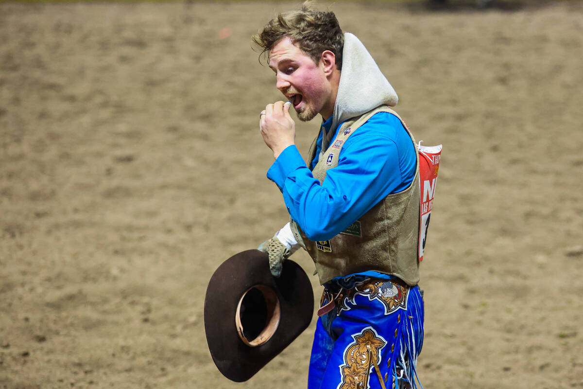 Bareback rider Dean Thompson takes his mouth guard out after his ride during round three of the ...