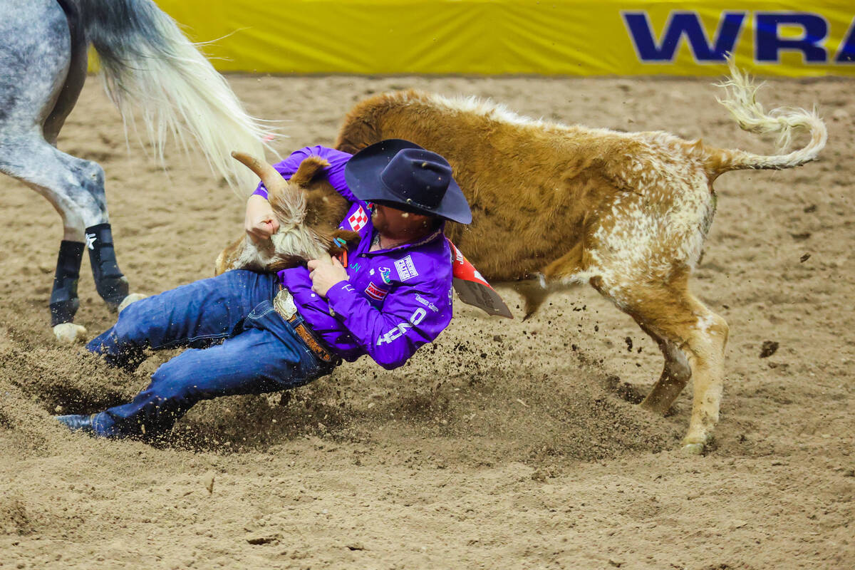 Steer wrestler Stetson Jorgensen wrestles a steer during round three of the National Finals Rod ...