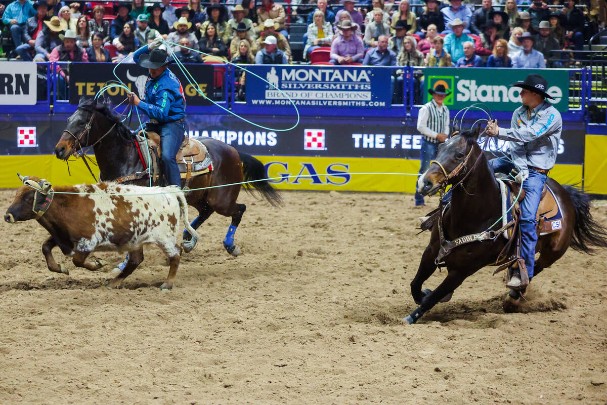 Team ropers Jake Smith and Douglas Rich rope a calf during round three of the National Finals R ...