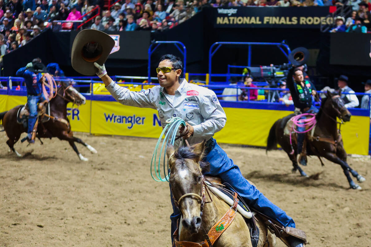 Team roper Junior Nogueira takes a victory lap during round three of the National Finals Rodeo ...