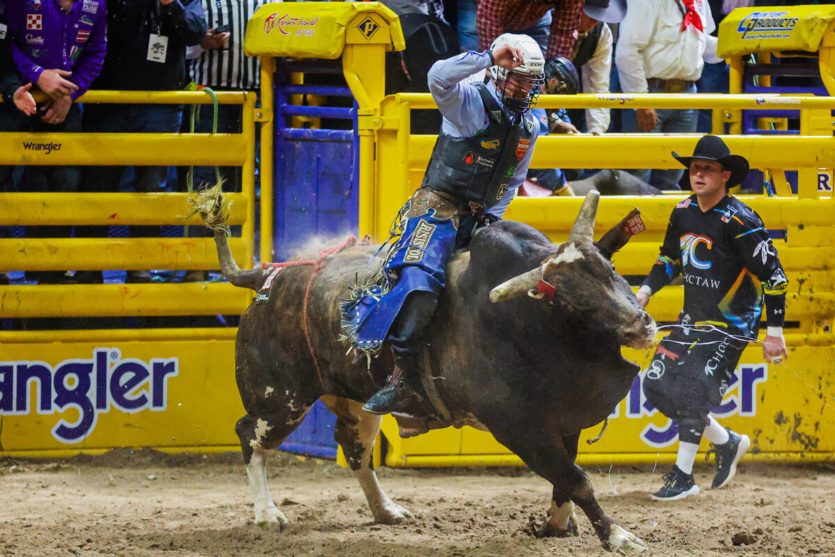 Bull rider Clayton Sellars comes out of the chute during round three of the National Finals Rod ...