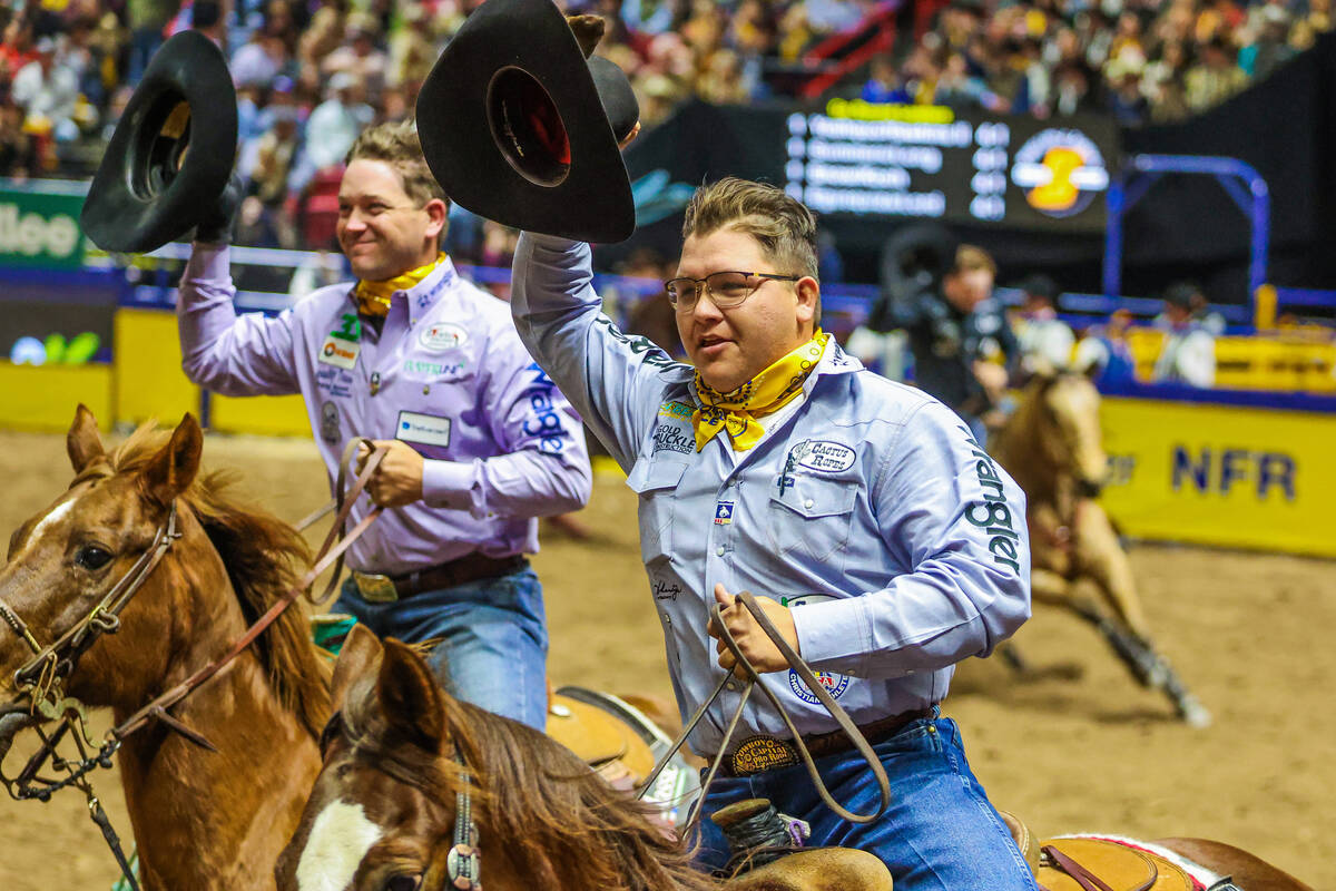 Team roping partners J.C. Yeahquo and Buddy Hawkins tip their hats to the crowd during a victor ...