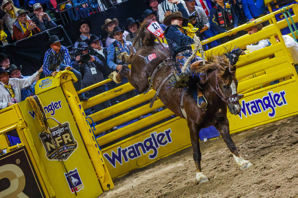 Saddle bronc rider Zeke Thurston bucks out of the chute on Buck Owens during round four of the ...