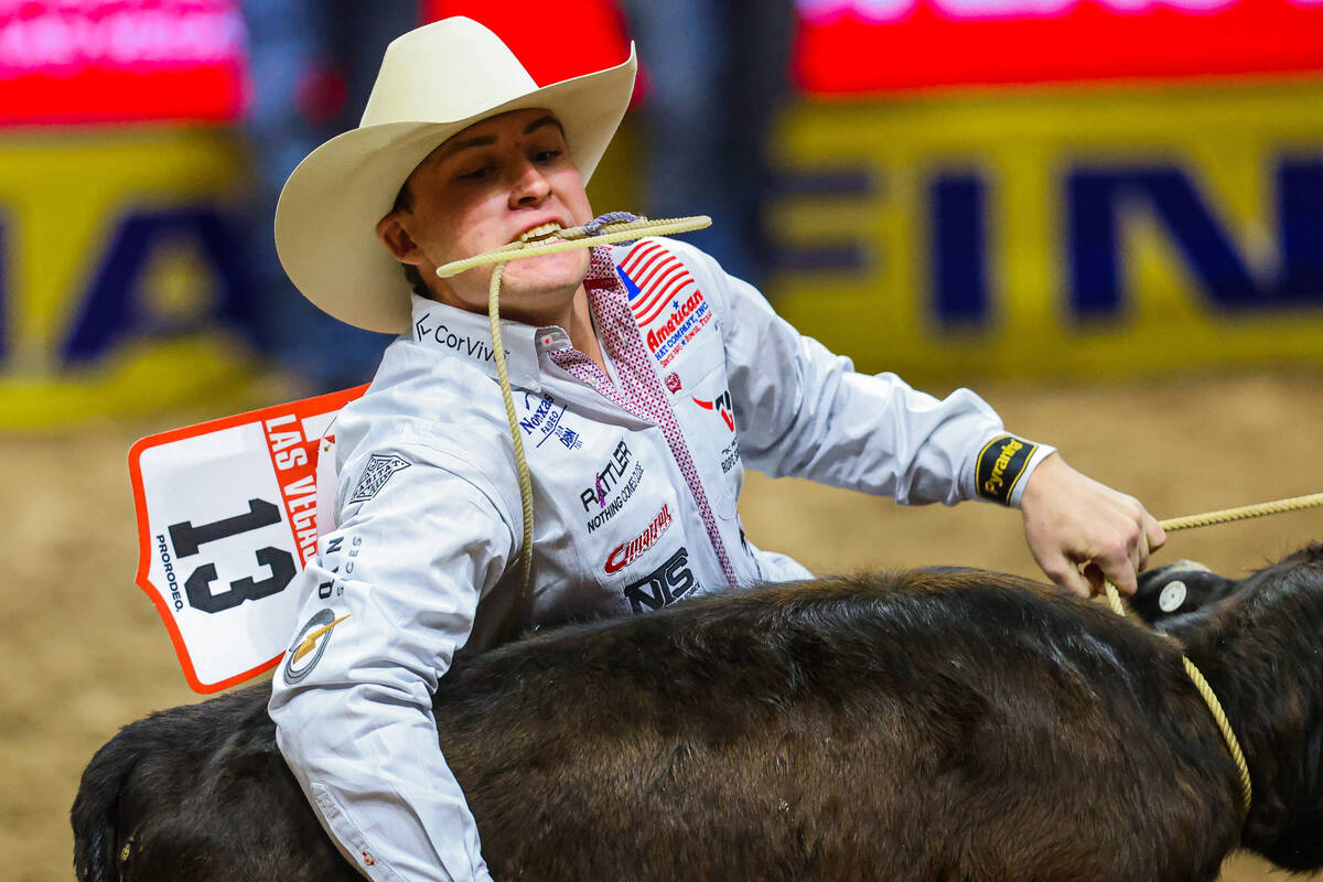 Tie-down roper Riley Webb picks up the calf during round four of the National Finals Rodeo at t ...