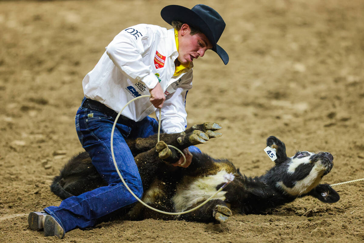 Tie-down roper Cole Clemons ties the calf up during round four of the National Finals Rodeo at ...