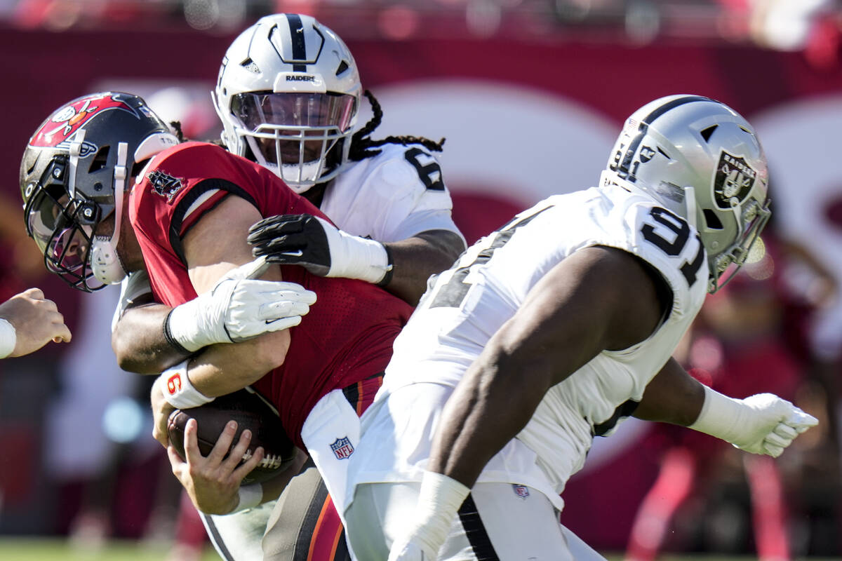 Las Vegas Raiders defensive tackle Adam Butler (69) sacks Tampa Bay Buccaneers quarterback Bake ...