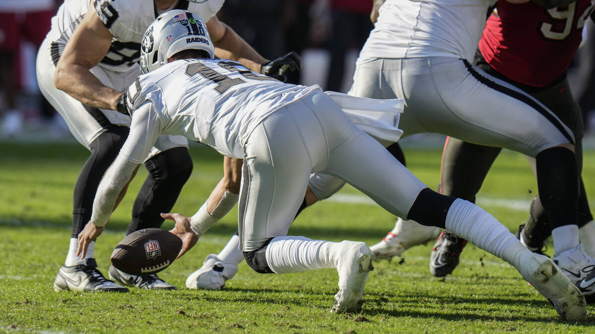 Las Vegas Raiders quarterback Desmond Ridder (10) dives onto his own fumble against the Tampa B ...