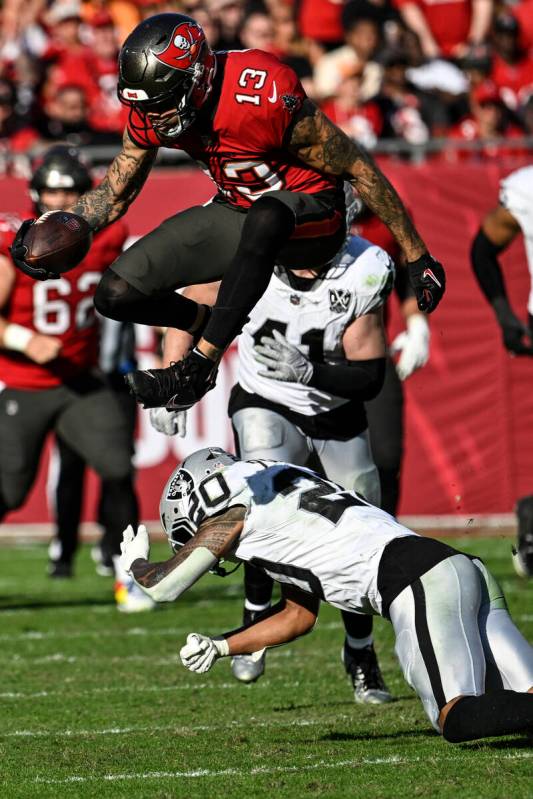 Tampa Bay Buccaneers wide receiver Mike Evans (13) leaps over Las Vegas Raiders safety Isaiah P ...