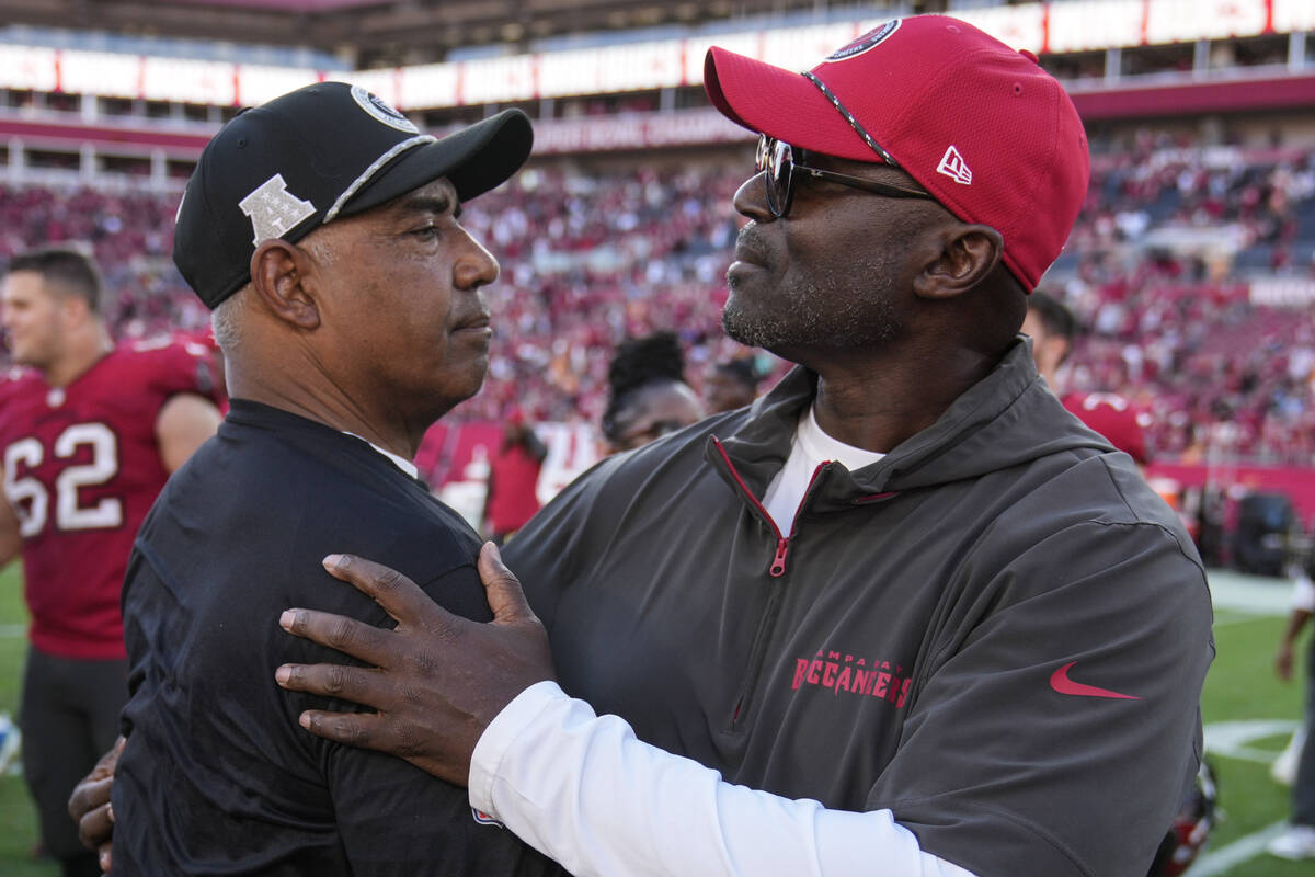 Tampa Bay Buccaneers head coach Todd Bowles, right, speaks with a Las Vegas Raiders coach durin ...