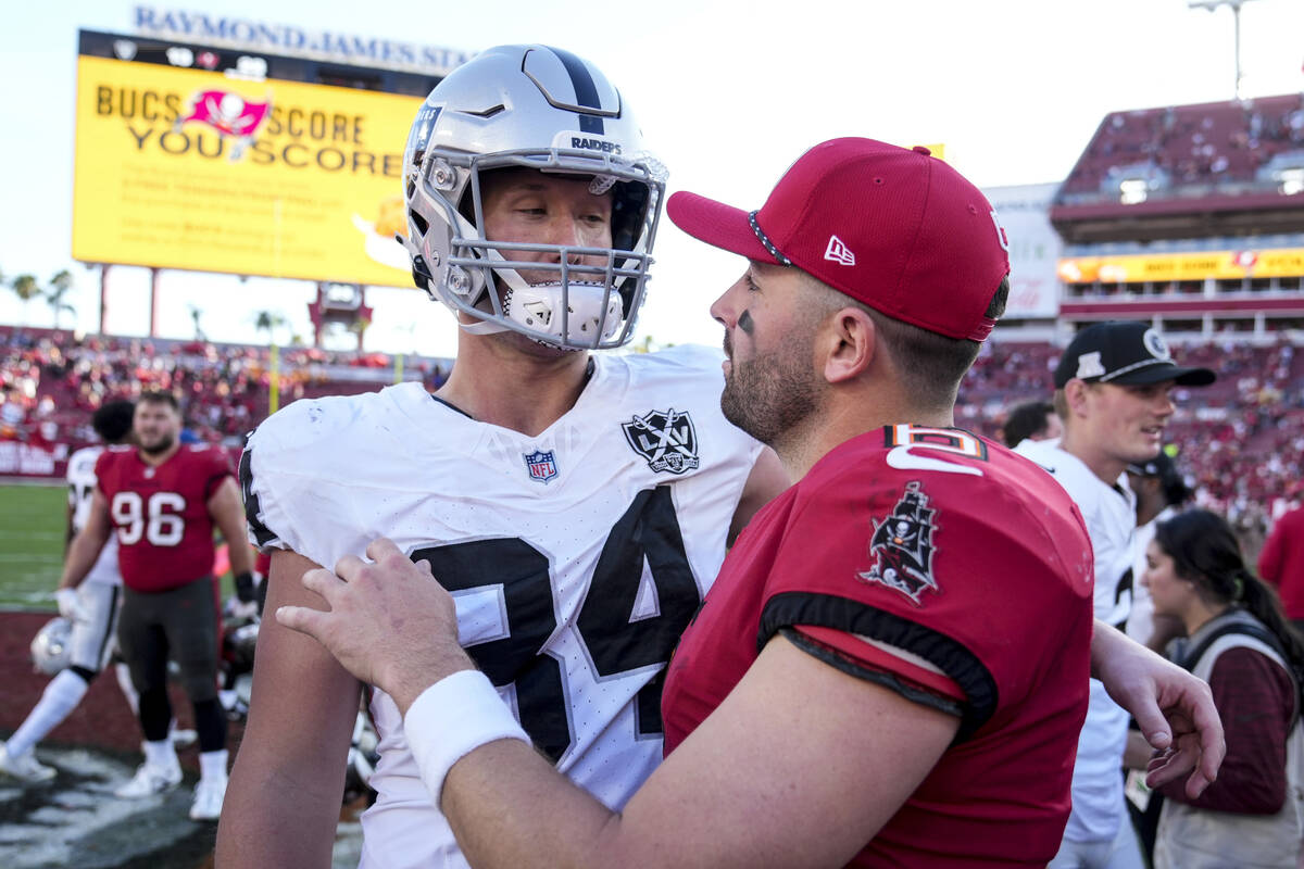 Tampa Bay Buccaneers quarterback Baker Mayfield (6) speaks with Las Vegas Raiders tight end Har ...