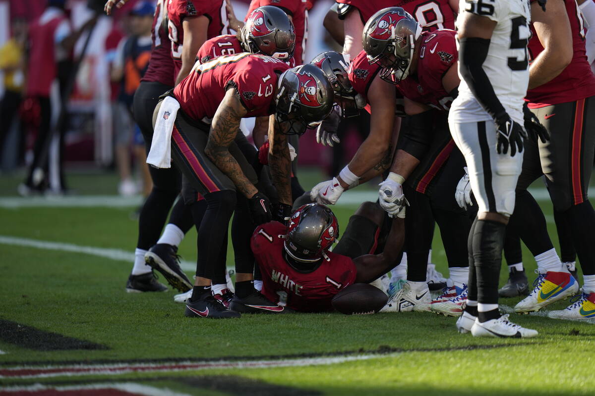 Tampa Bay Buccaneers players help up running back Rachaad White (1) after his touchdown against ...