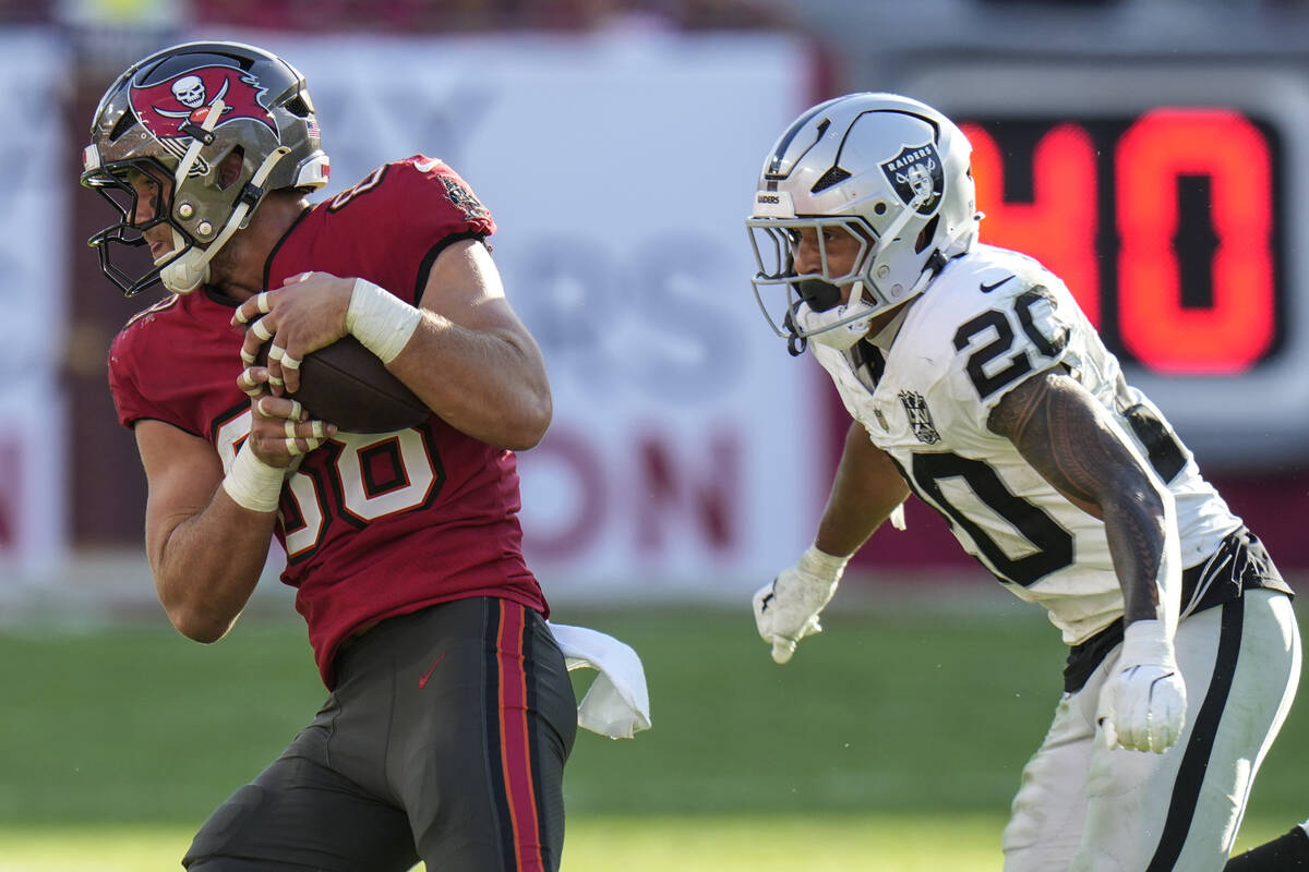 Tampa Bay Buccaneers tight end Cade Otton (88) runs past Las Vegas Raiders safety Isaiah Pola-M ...