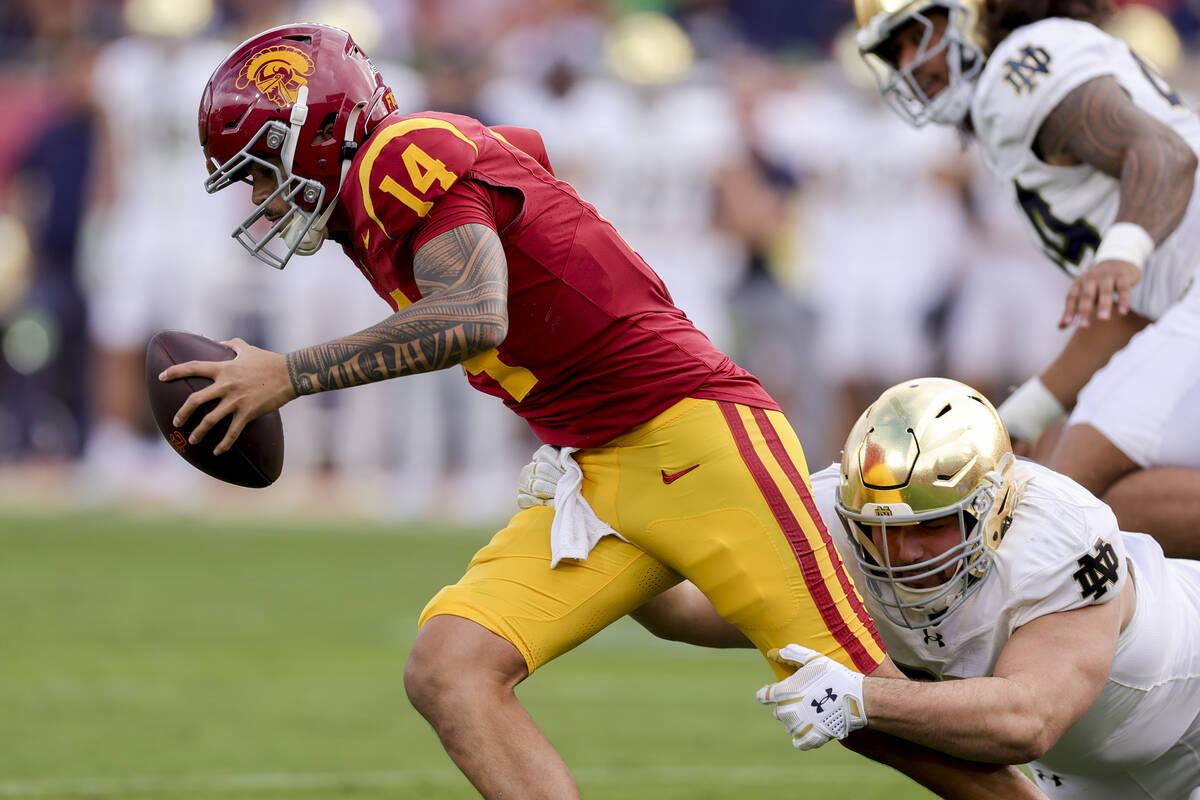 Southern California quarterback Jayden Maiava, left, is sacked by Notre Dame defensive lineman ...