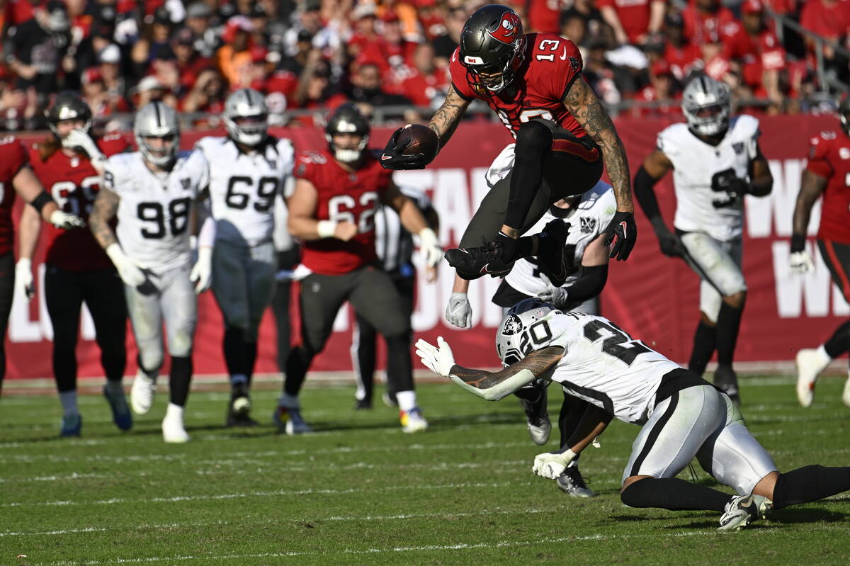 Tampa Bay Buccaneers wide receiver Mike Evans (13) leaps over Las Vegas Raiders safety Isaiah P ...