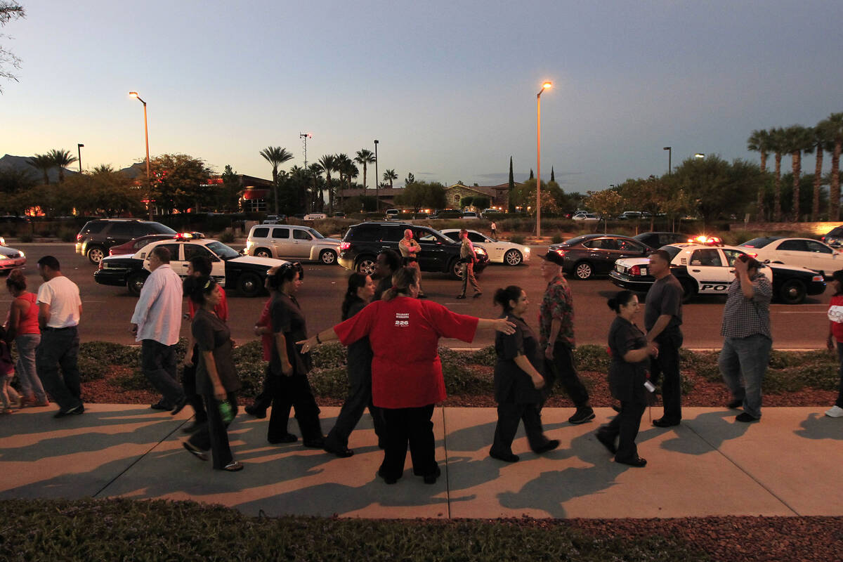 Union members and supporters march along the sidewalk during a Culinary Local 226 protest outsi ...