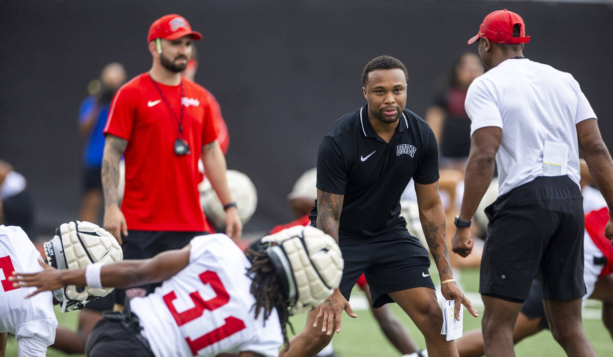 UNLV Offensive Coordinator/Quarterbacks Brennan Marion talks with cornerbacks coach Akeem Davis ...