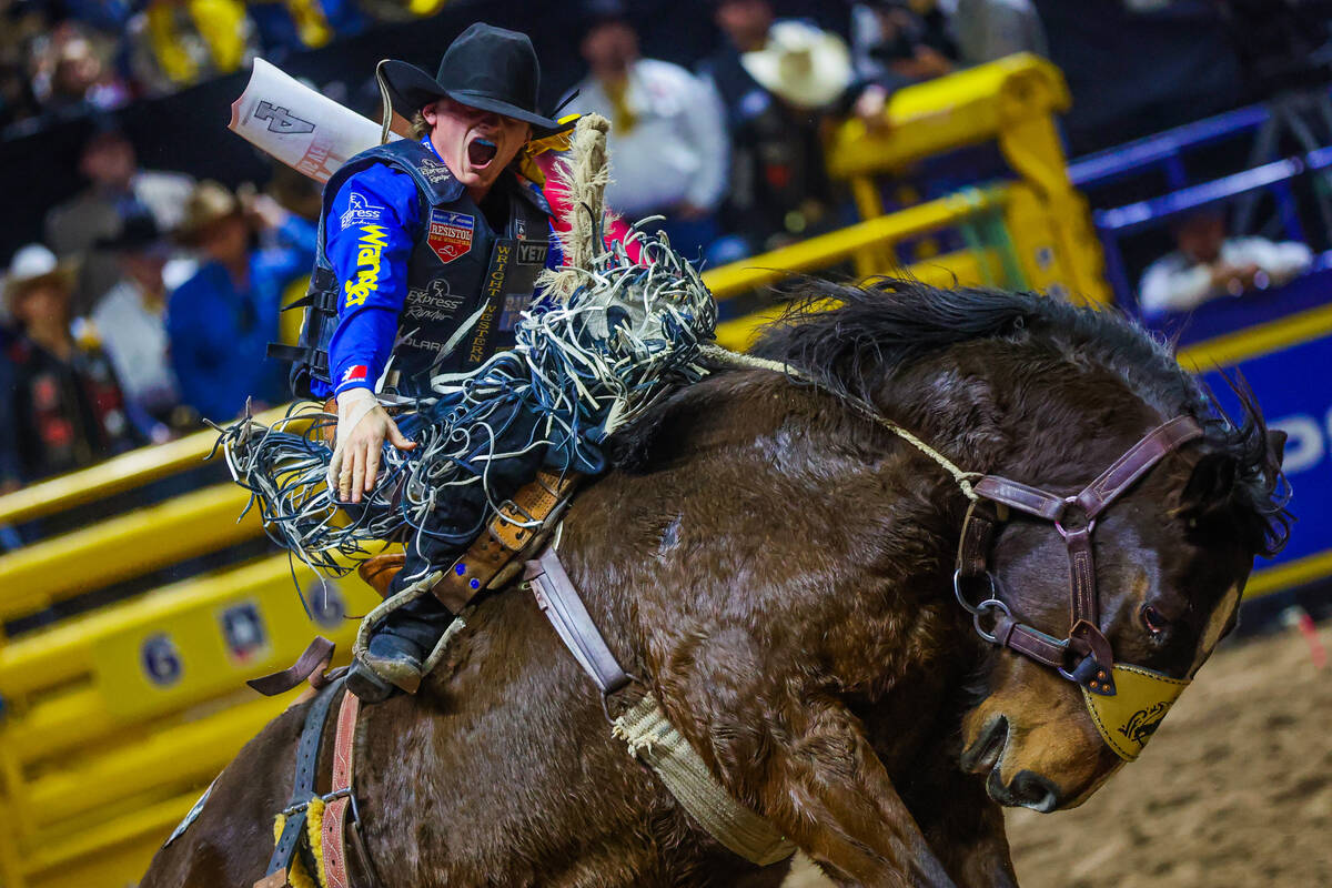 Saddle bronc rider Ryder Wright gets amped up during his ride on Tickled Pink during round four ...