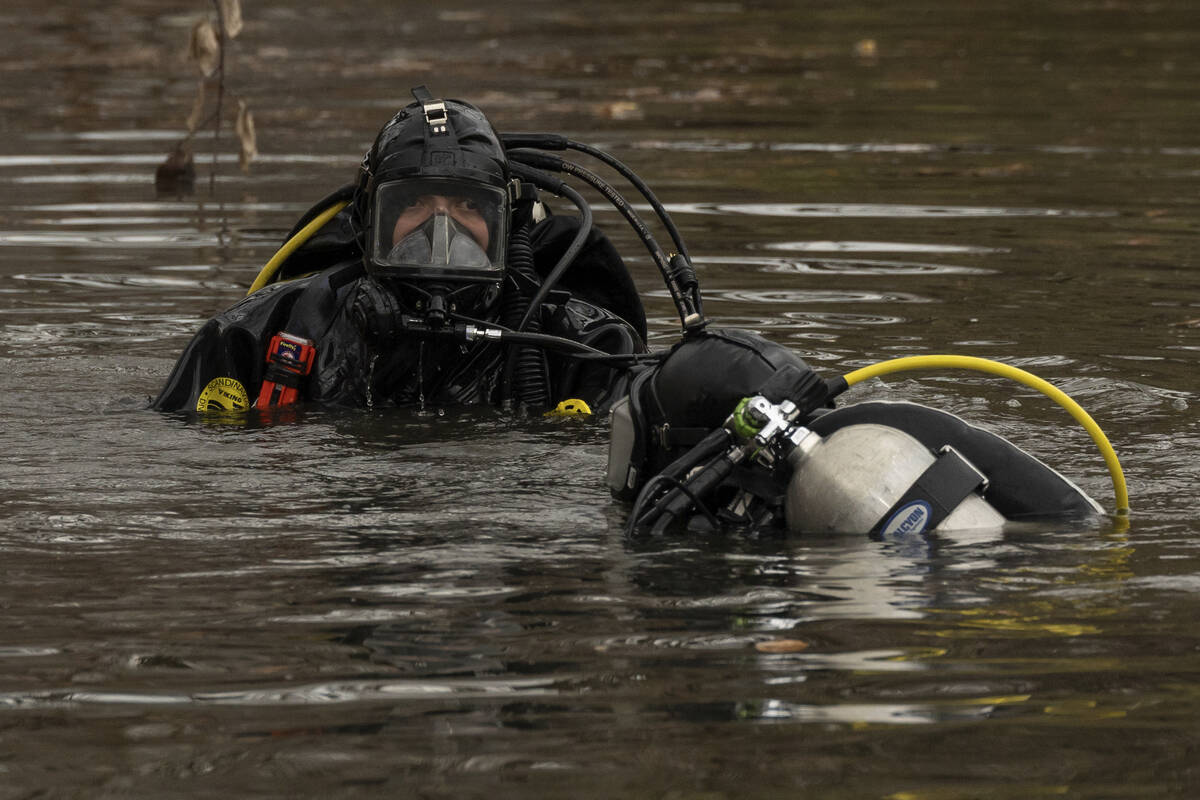 NYPD officers in diving suits search a lake in Central Park, Monday, Dec. 9, 2024, in New York. ...