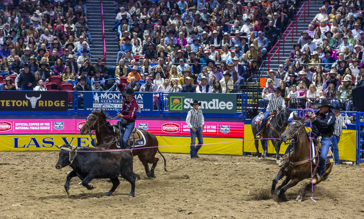 Team Roping header Clay Smith, right, and heeler Coleby Payne work to rope their calf during Na ...