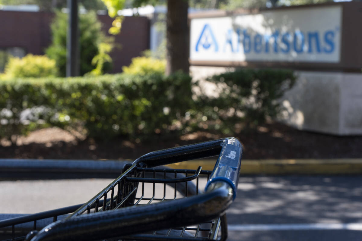 FILE - A grocery cart rests in a cart return area with a sign for Albertsons grocery store in t ...