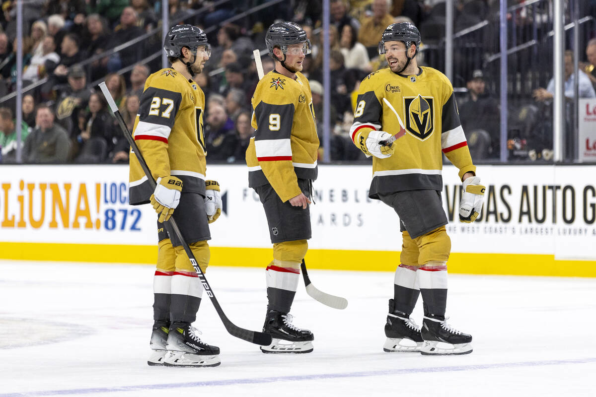 Golden Knights defenseman Shea Theodore (27) and center Jack Eichel (9) listen to center Tomas ...