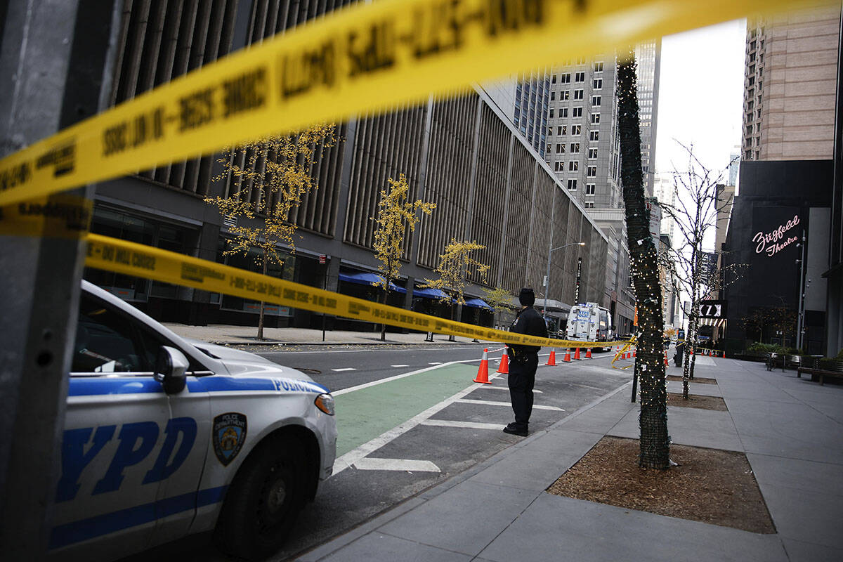 A New York police officer stands on 54th Street outside the Hilton Hotel in midtown Manhattan w ...