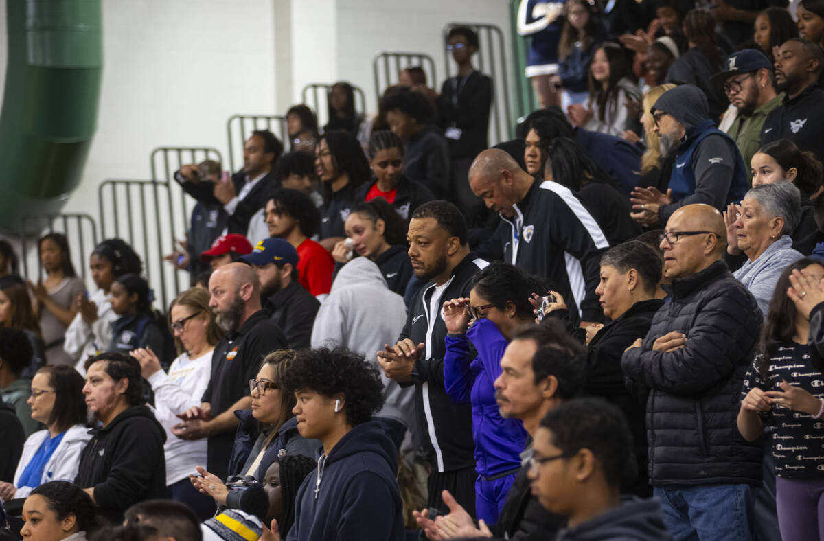 People, including family and friends, stand for a moment of silence in honor of community figur ...