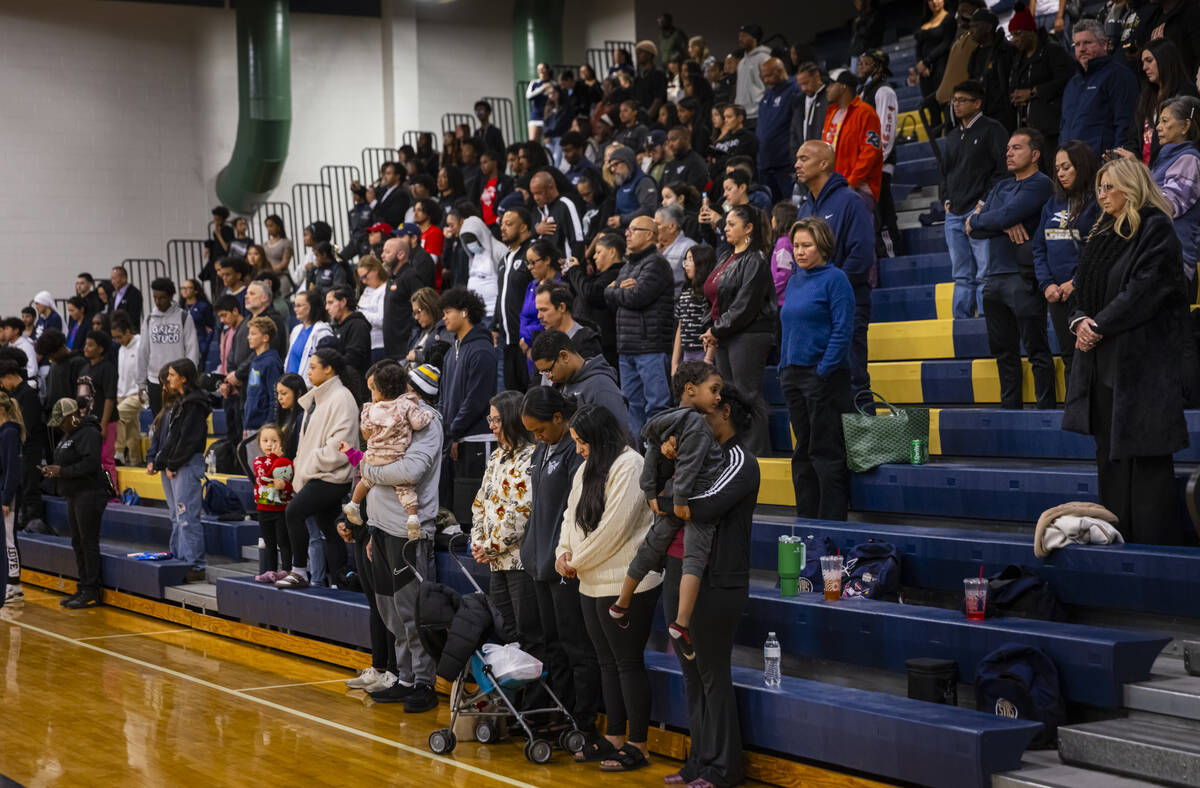 People stand for 30 seconds of silence in honor of community figure and basketball coach Abdul ...