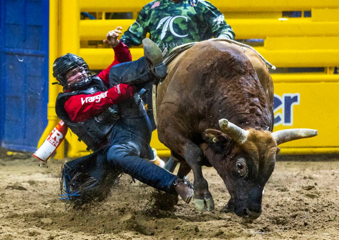 Bull Riding contestant Wacey Schalla gets his boot hung up over his cinched hand while riding D ...