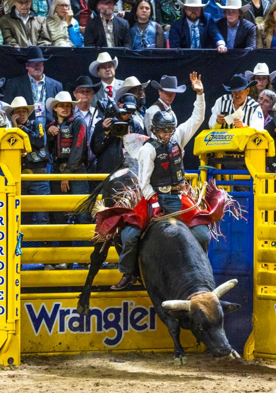 Bull Riding contestant Cooper James rides Midnight Rider to a winning score during National Fin ...