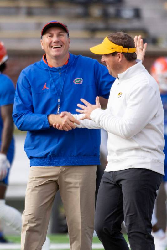 Florida coach Dan Mullen, left, greets Missouri coach Eliah Drinkwitz before an NCAA college fo ...