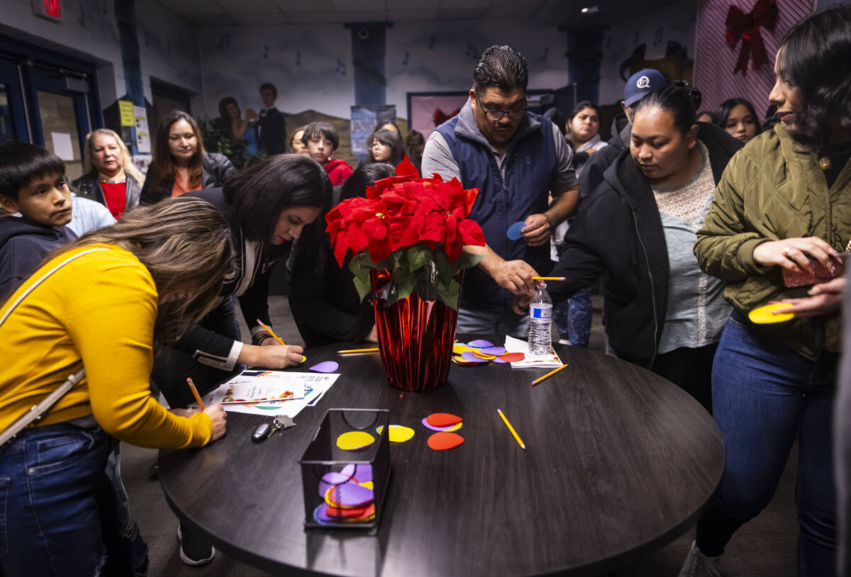 Parents and family members fill out words of encouragement on cards for their children followin ...