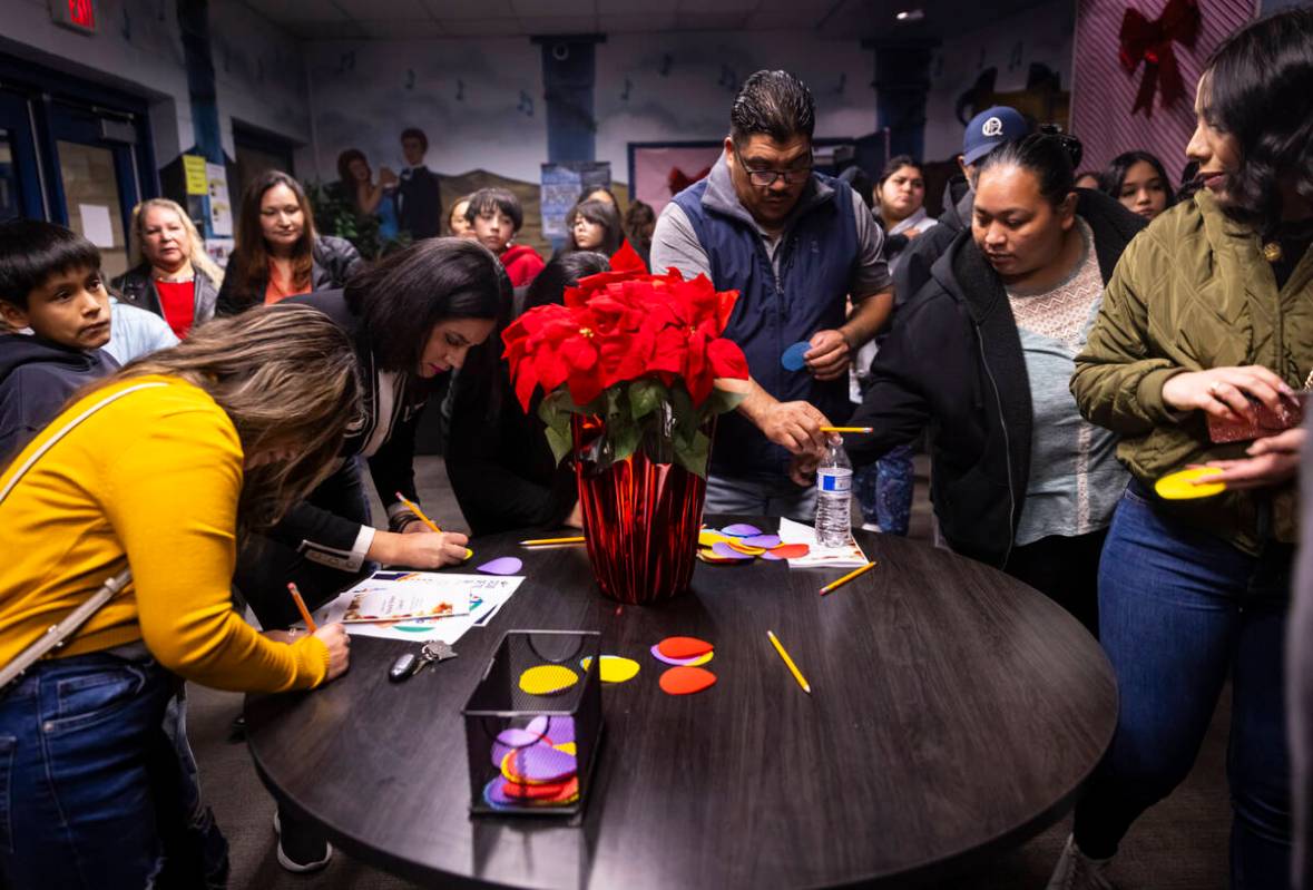 Parents and family members fill out words of encouragement on cards for their children followin ...