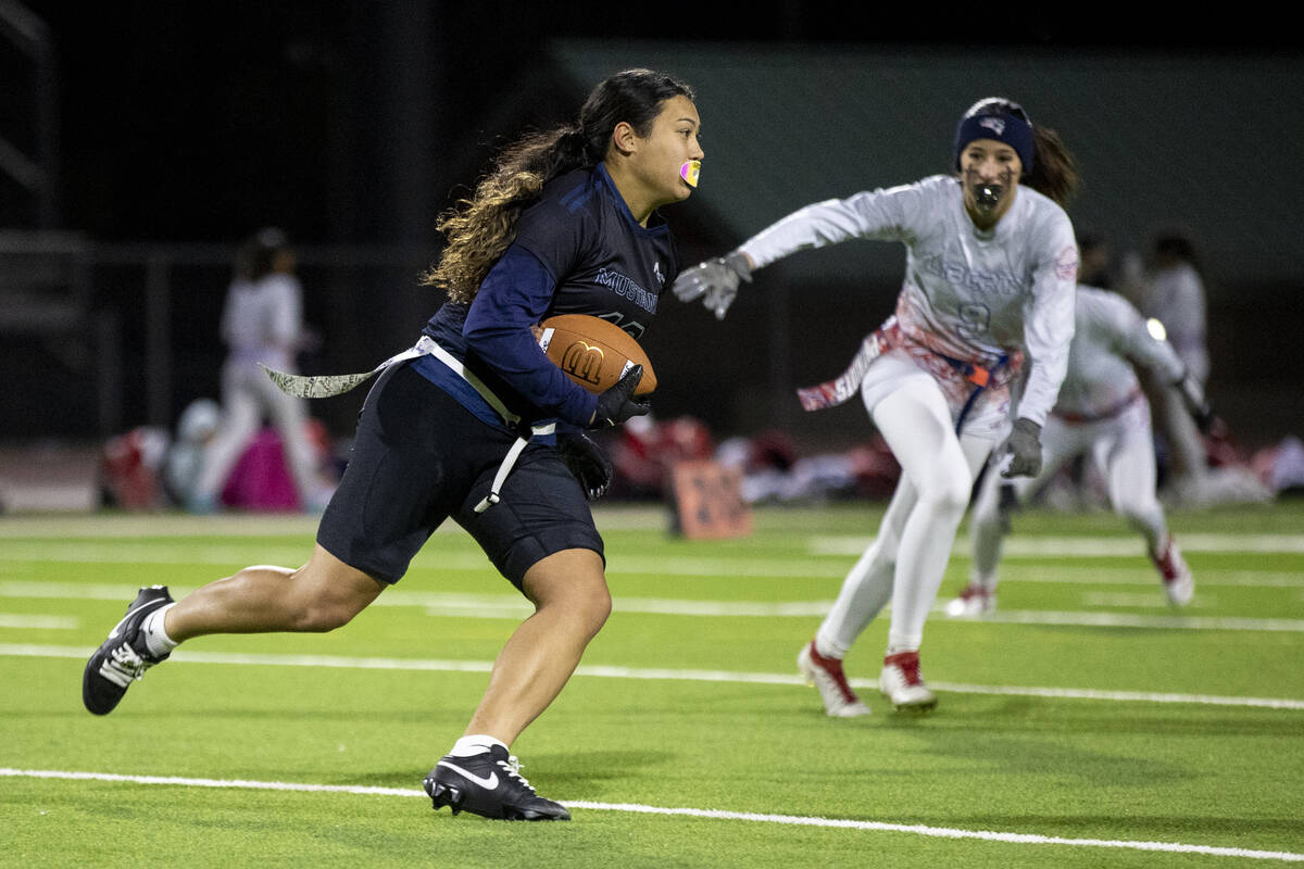 Shadow Ridge junior Jaylani Palmer (12) runs with the ball during the high school flag football ...