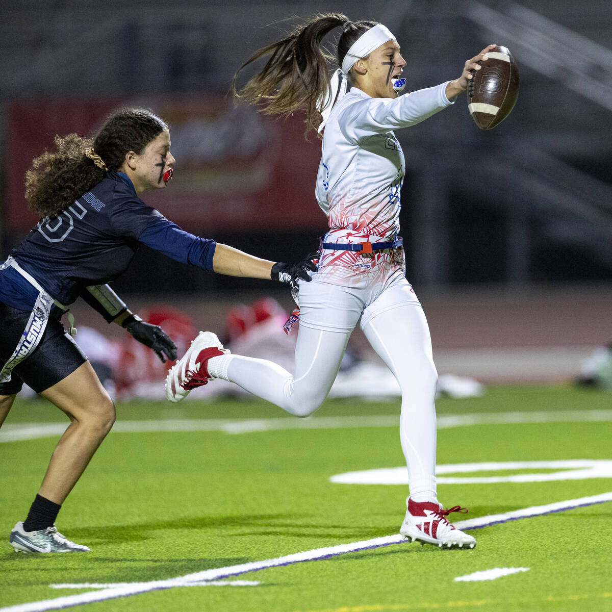 Liberty senior Kaylie Phillips, right, runs into the end zone during the high school flag footb ...