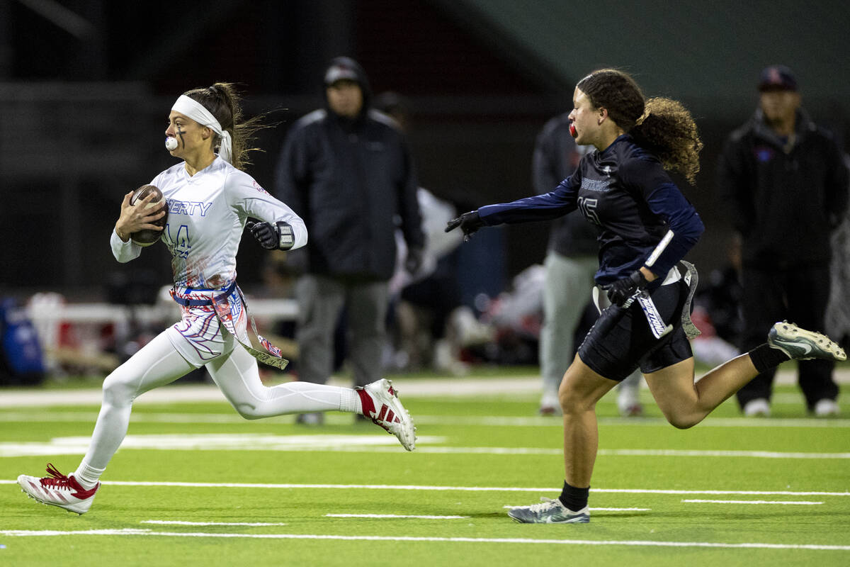 Liberty senior Kaylie Phillips (14) outruns Shadow Ridge junior Mariah Stevens-Walden (15) duri ...