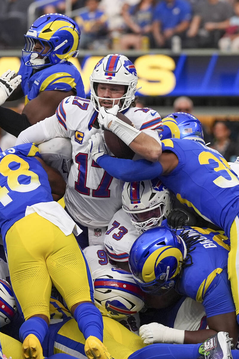 Buffalo Bills quarterback Josh Allen, top center, scores a touchdown on a keeper against the Lo ...