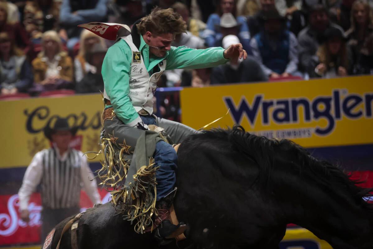 Cooper Cooke competes in bareback riding during the 8th go-round of the National Finals Rodeo a ...