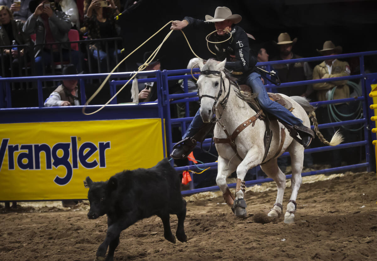 Tuf Cooper competes in tie-down roping during the 8th go-round of the National Finals Rodeo at ...