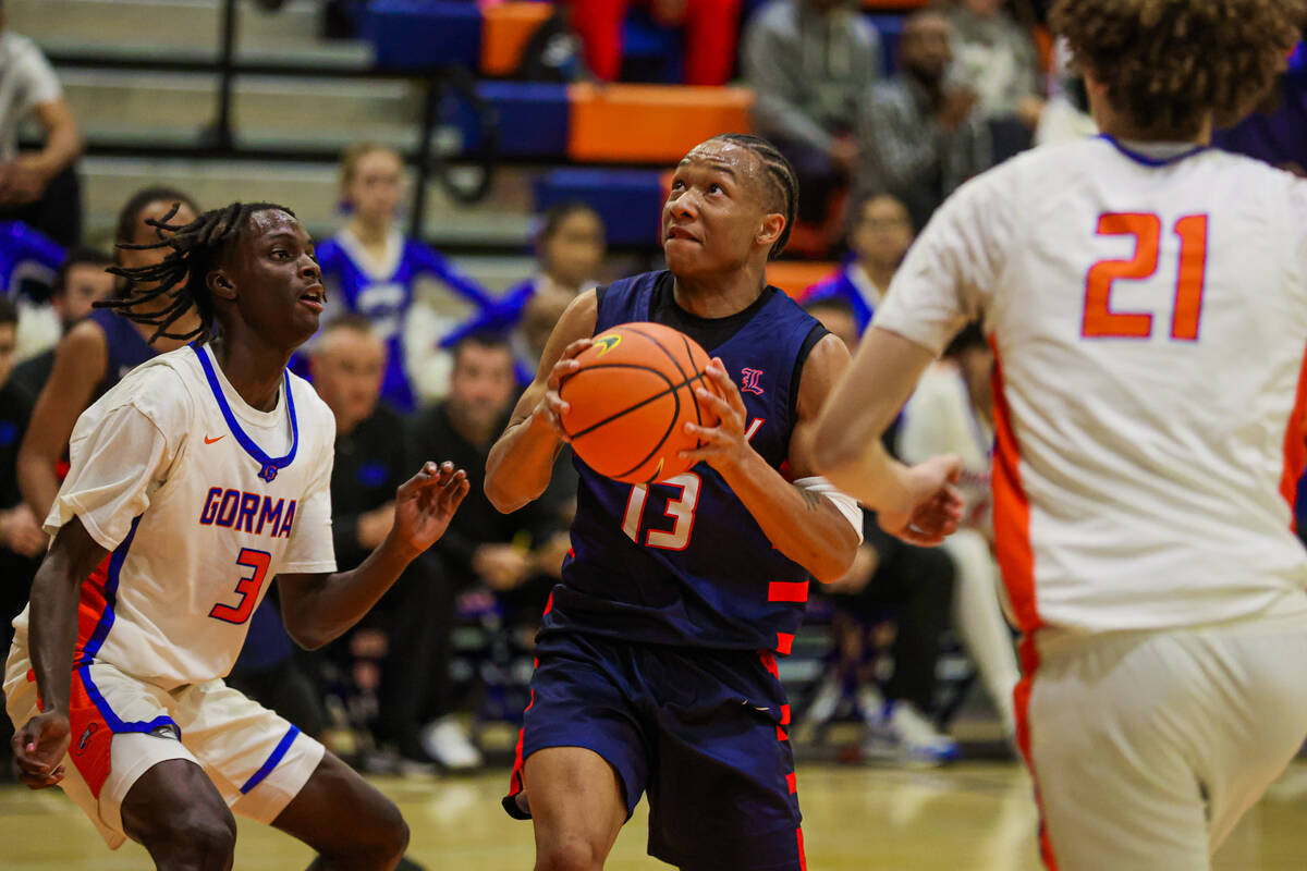 Liberty point guard Jaden Riley (13) eyes the basket as he drives the ball during a basketball ...