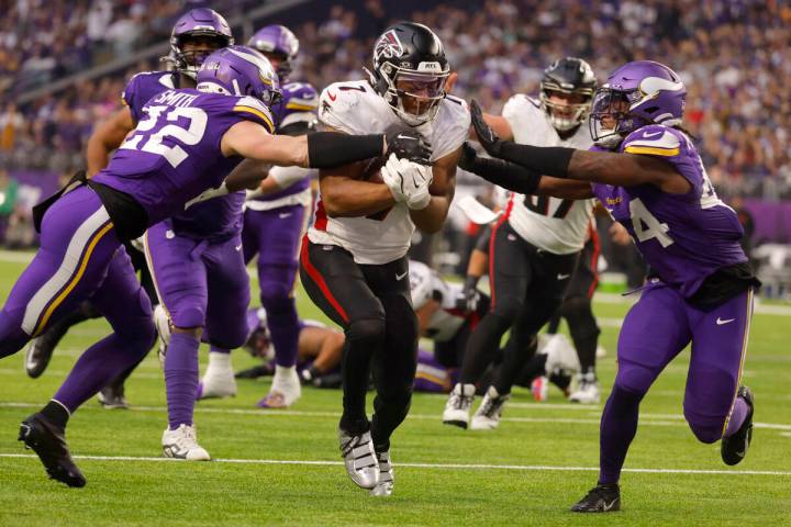 Atlanta Falcons running back Bijan Robinson (7) scores on a 13-yard touchdown run between Minne ...