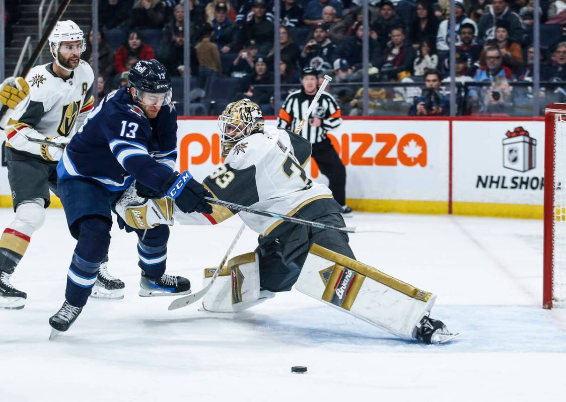 Winnipeg Jets' Gabriel Vilardi (13) tries to break around Vegas Golden Knights goaltender Adin ...