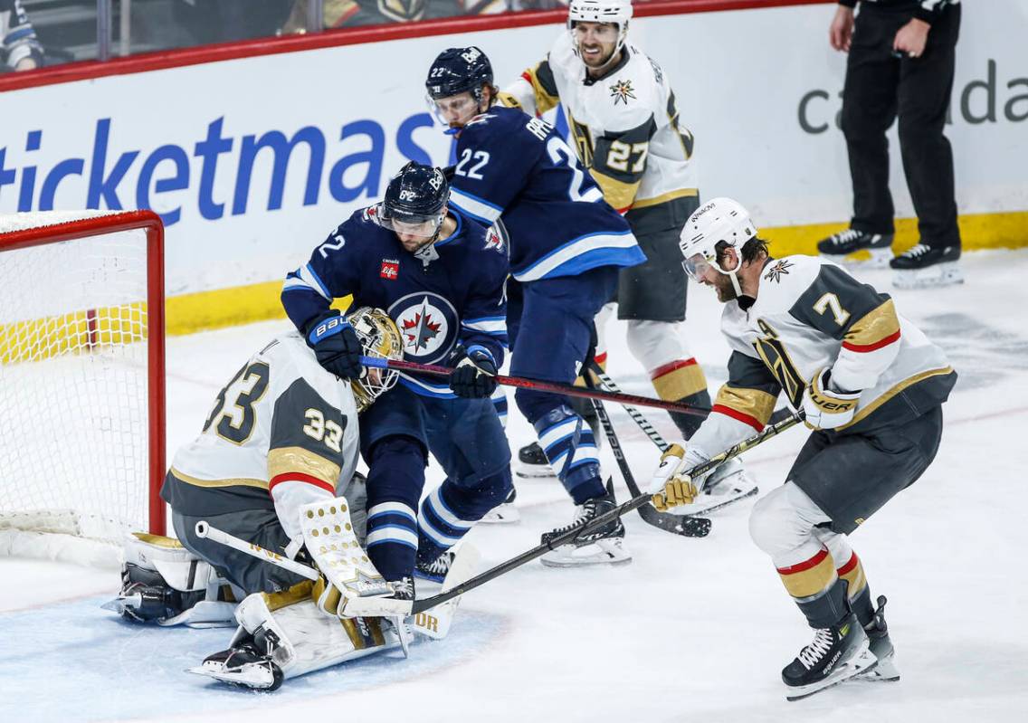 Winnipeg Jets' Nino Niederreiter (62) shot crawls over the pads of Vegas Golden Knights goalten ...