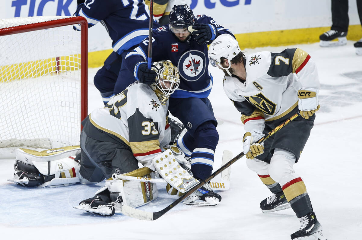 Winnipeg Jets' Nino Niederreiter (62) shot crawls over the pads of Vegas Golden Knights goalten ...