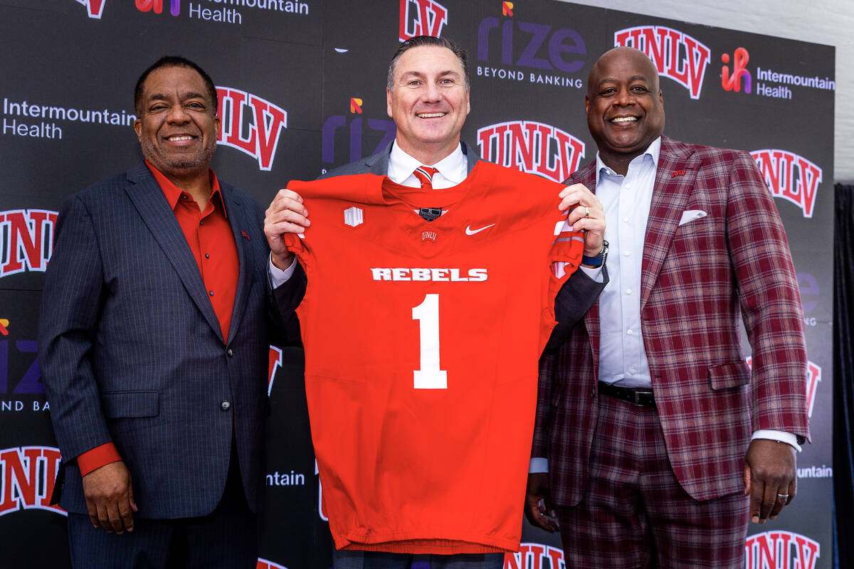 UNLV introduces Dan Mullen, center, with a jersey beside President Keith Whitfield, left, and ...